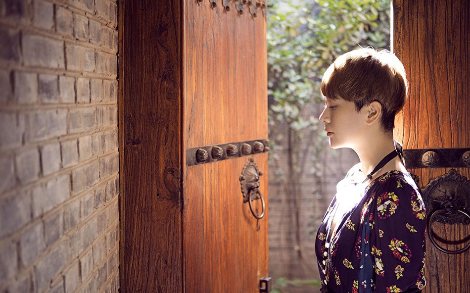 海清演绎自然系文艺风韵 柔和逆光中海清低头沉思,发梢与肩颈沐浴在金色光晕之中