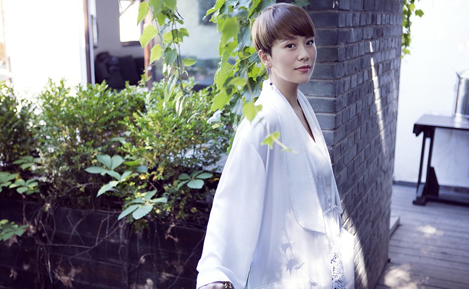 海清演绎自然系文艺风韵 海清坐姿放松展露恬静微笑,宽松剪裁与随意露肩尽显自在韵味
